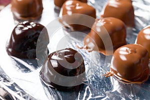 Heart-shaped sweets covered with liquid icing black chocolate