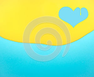 Heart shaped symbol made of dripping yellow paint on blue background
