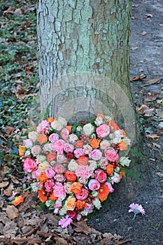 Heart shaped sympathy wreath near a tree