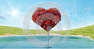 Heart shaped tree with red leaves growing in the lake in the grass field