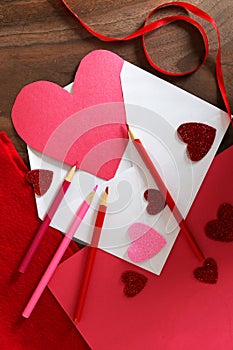 Heart Shaped Valentine`s Day Card in Envelope on Table with Art Supplies