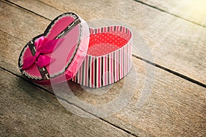 Heart shaped Valentines Day gift box on old vintage wooden plate