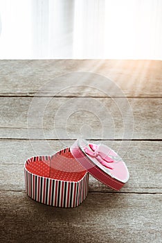 Heart shaped Valentines Day gift box on old vintage wooden plate