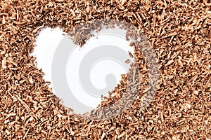 Heart-shaped and wood saw dust on dirty white background