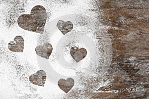 Heart shapes made of flour on wooden table. Space for text