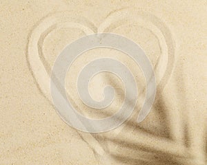 Heart Sign painted on the sand and palm leaf shadow