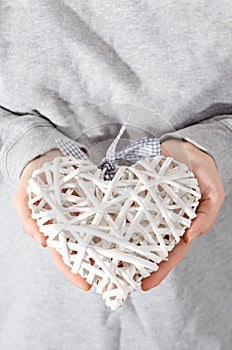 Heart of straw held in hands by women