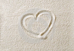 Heart symbol drawn in sand surface macro photo photo