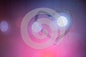 heart symbol hand drawn on wet night window glass in pink colors