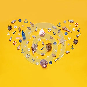 Heart symbol made of decorative items and miniature toys: seashells, seastar, boat, vessel, anchors, steering wheels, life buoys.