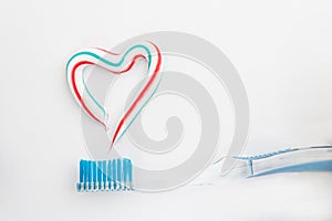 The heart symbol is made from a three-color toothpaste and is located above the toothbrush