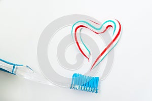 The heart symbol is made from a three-color toothpaste and is located above the toothbrush