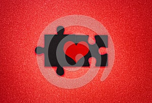 Heart symbol made of two black puzzles on a red background. Matching souls love concept