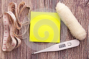 heart symbols and blank yellow sticky note on wooden background. Conceptual. Copy space.