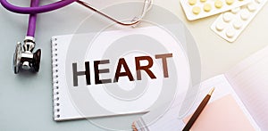 Heart. Text on notepad wirh stethoscope on medical background