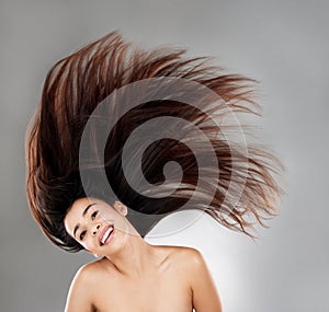 He heart is a thousand years old. Studio portrait of a beautiful young woman with flowing hair against a grey background