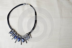 Heart to Valentine`s Day from a beautiful, feminine, fashionable necklace on a black rubber band with blue shining gems, diamonds