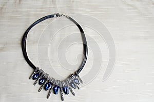 Heart to Valentine`s Day from a beautiful, feminine, fashionable necklace on a black rubber band with blue shining gems, diamonds