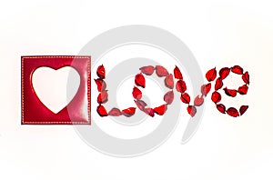 Heart and word love laid out from artificial flowers on a white background
