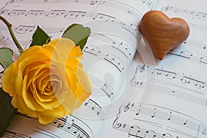 Heart and yellow rose on a sheet of music