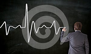 Heartbeat is painted on blackboard by businessman