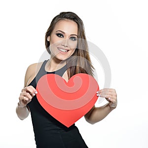 Heartbreaker. Temptress. Seductive woman. Portrait of amazing young fashion woman posing at studio with red heart. Love. Valentine