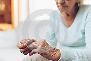 Heartbroken elderly woman holding a wedding ring