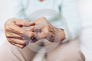 Heartbroken elderly woman holding a wedding ring