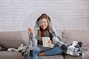 Heartbroken young woman eating ice cream from bucket while watching romantic movie on TV, feeling depressed and lonely