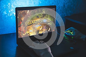 Hearthstone is a free-to-play online digital collectible card game. Video computer game. Man play video game on laptop