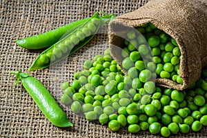 Hearthy fresh green peas and pods on rustic fabric photo