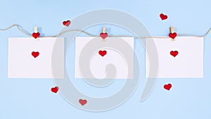 Hearts appear on papers and around papers on blue theme. Stop motion