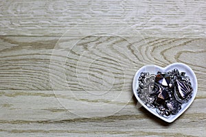 Hearts beads of metal on wooden background.