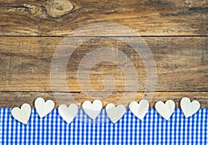 Hearts border on blue white checkered fabric and wooden board.