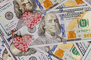Hearts with colorful decorative stones on undred dollar bill money