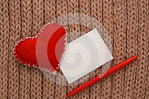 Hearts cut from fabric on a thread, on a knitted background. Valentine day card