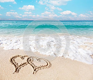 Hearts drawn on the beach sand.