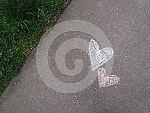 Hearts drawn with chalk on the asphalt sidewalk