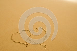 Hearts drawn on the sand of beach