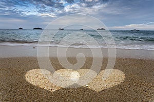 Hearts Light in Sand on Ocean Beach.