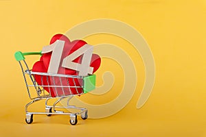 Hearts in shopping push cart on yellow background, sales and love concept, valentine's day