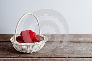 Hearts in wicker basket, on rustic wooden