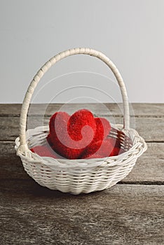 Hearts in wicker basket, on rustic wooden