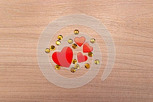 Hearts on wooden background with sparkles. Valentine's Day or Mother's Day greeting card.