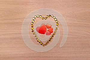 Hearts on wooden background with yellow sparkles. Valentine's Day or Mother's Day greeting card.