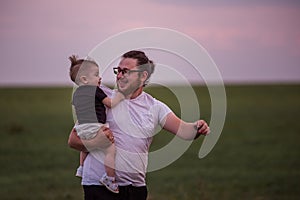 Heartwarming scene of diversity father carrying smiling son on shoulders at twilight, Fathers day