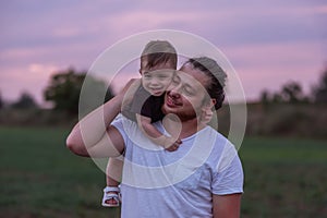 Heartwarming scene of diversity father carrying smiling son on shoulders at twilight, Fathers day