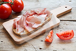 Hearty bread with ham bacon on a wooden board