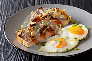 Hearty breakfast of fried toast with shiitake mushrooms and cheddar cheese served with eggs close-up on a plate. horizontal