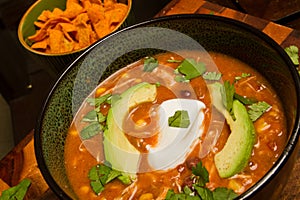 Hearty Chicken Enchilada Soup with Avocado and Sour Cream Garnish Close-Up